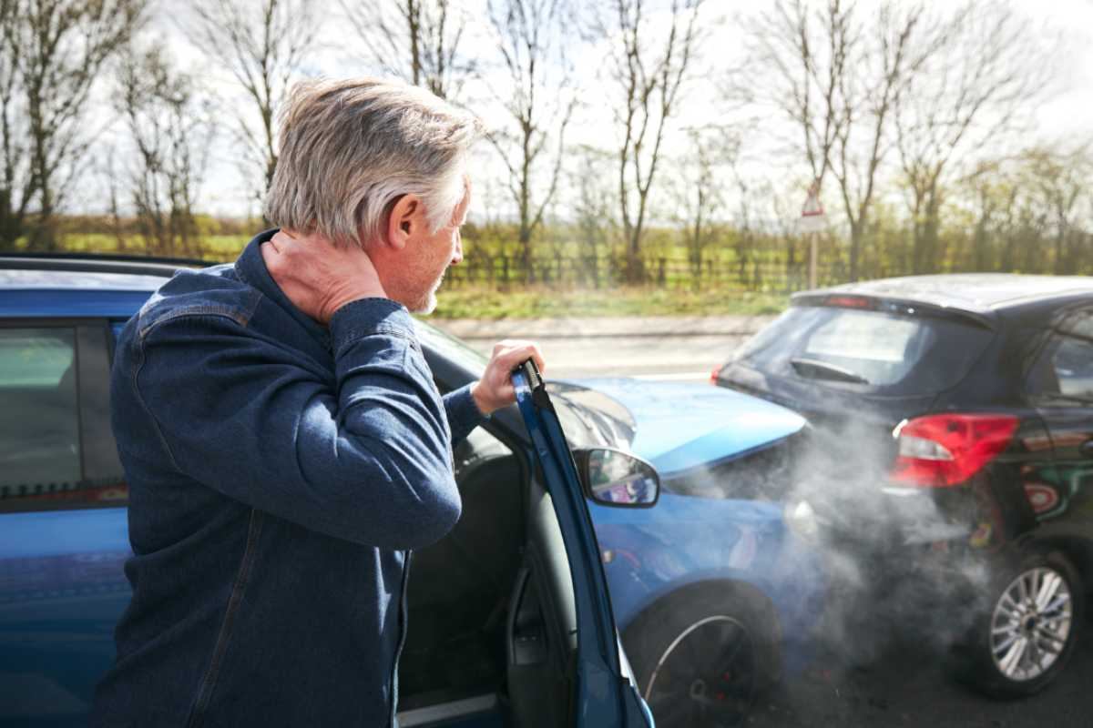 Uomo esce con collo dolorante da auto dopo incidente